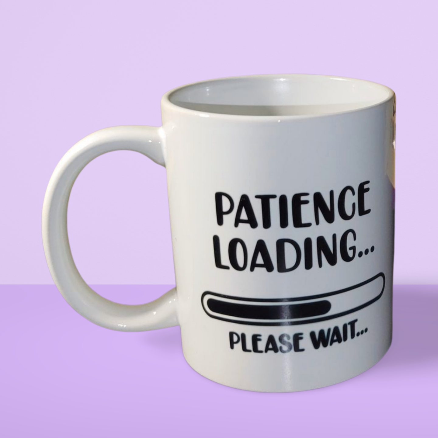 A white ceramic mug with the text 'Patience Loading... Please Wait...' in black lettering.