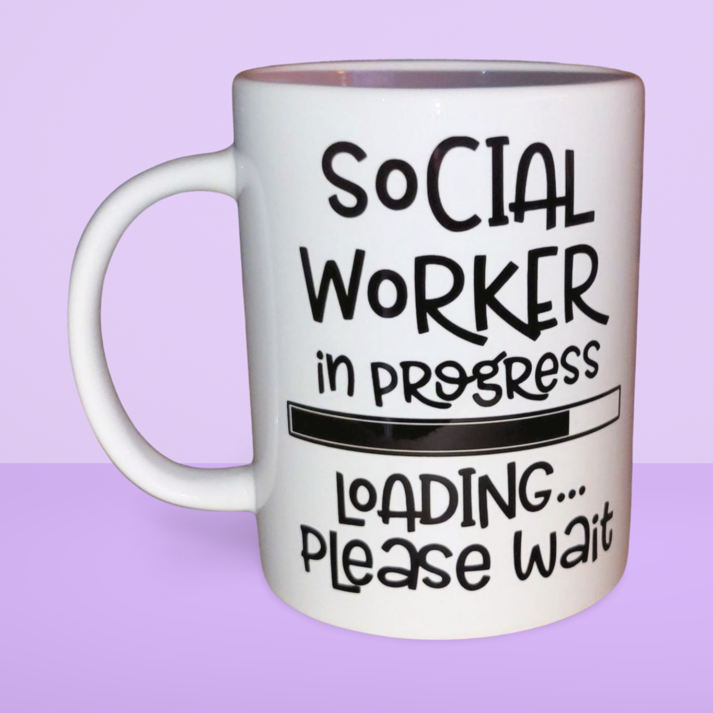 A white ceramic mug with the text 'Social Worker in progress Loading... Please wait' printed on it.