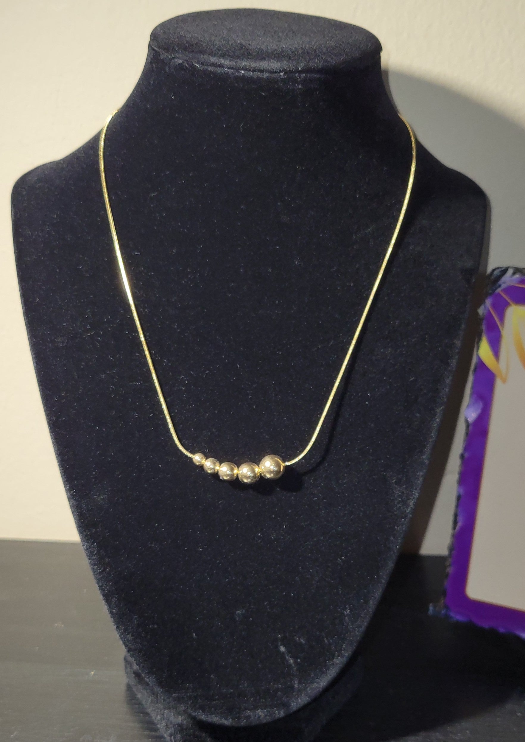 gold-plated snake chain necklace with graduated beaded design.