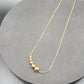 A gold-plated snake chain necklace with graduated beaded design.