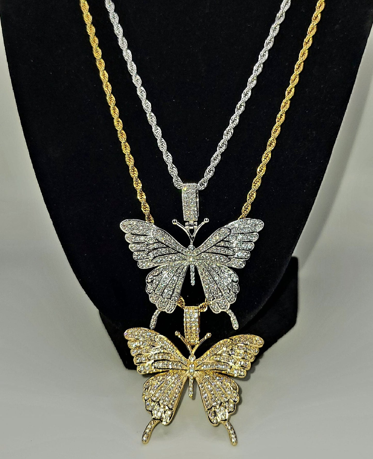 A gold-colored butterfly charm and a silver-colored butterfly charm.