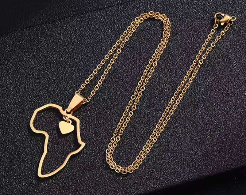A gold necklace with a pendant in the shape of Africa's map, featuring a heart symbol on the continent's center.