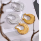 A pair of hoop earrings in gold color and a pair in silver color.