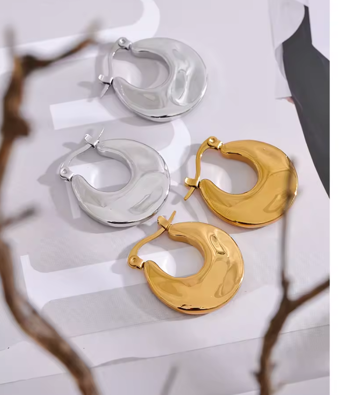 A pair of hoop earrings in gold color and a pair in silver color.