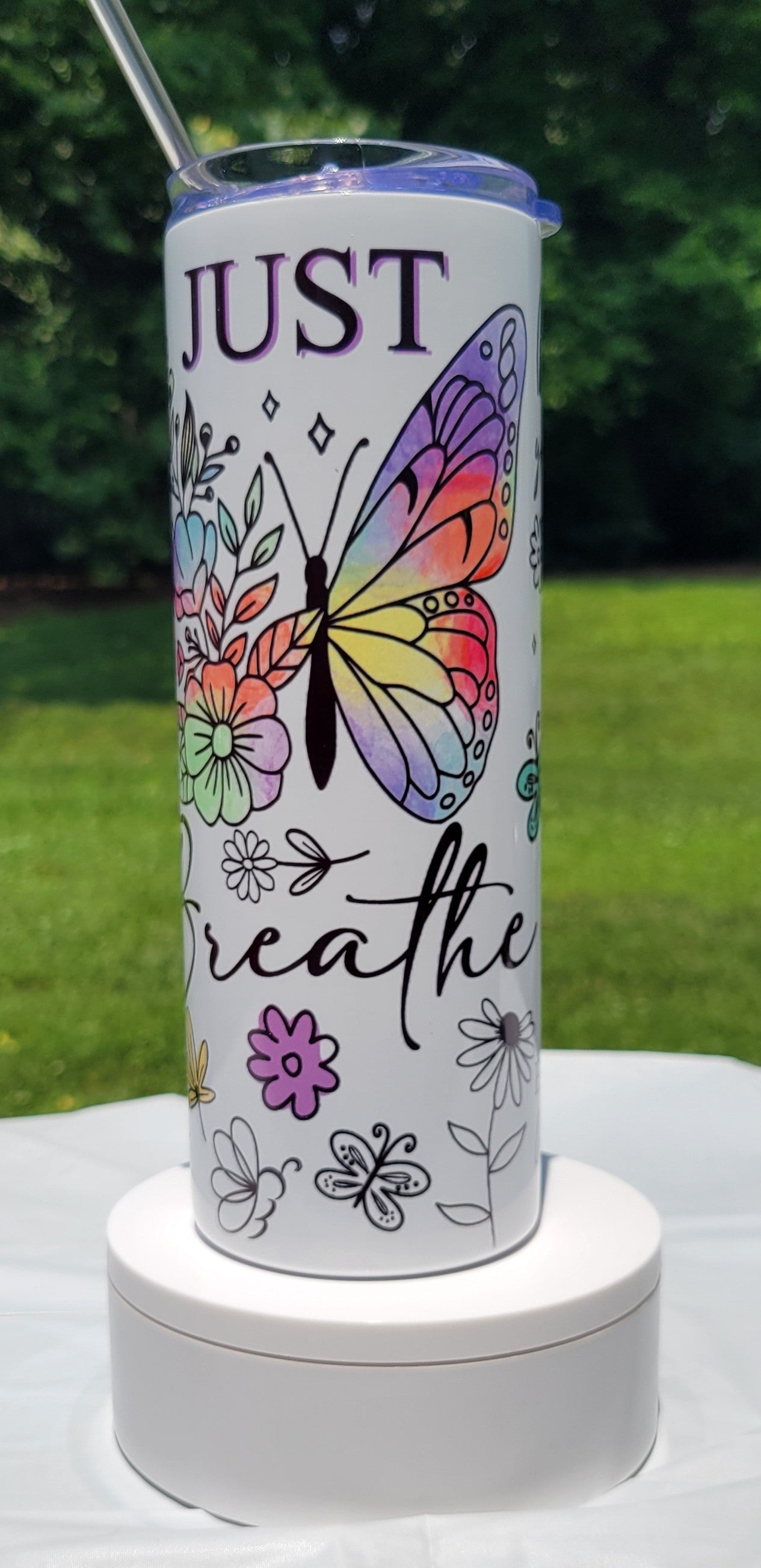 Tumbler with butterfly design and 'Just Breathe' text on a white background